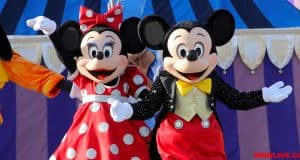 Mickey and Minnie Mouse wave to guests on a vibrant striped stage at Disney World, capturing the magic of this favorite attraction.