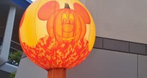 Giant inflatable Mickey Mouse pumpkin with candy corn accents decorates Main Street for a festive Disney Parks Halloween celebration.