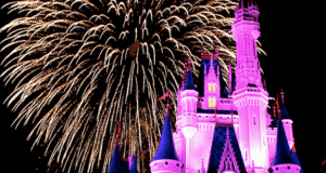 Cinderella Castle glows pink at Walt Disney World as dazzling fireworks burst overhead, creating a magical nighttime spectacle.