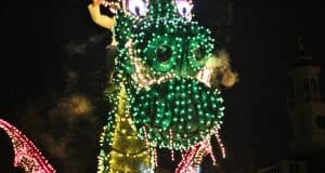 Maleficent dragon float glowing with colorful lights and smoky breath dazzles crowds during Disney World's nighttime parade.