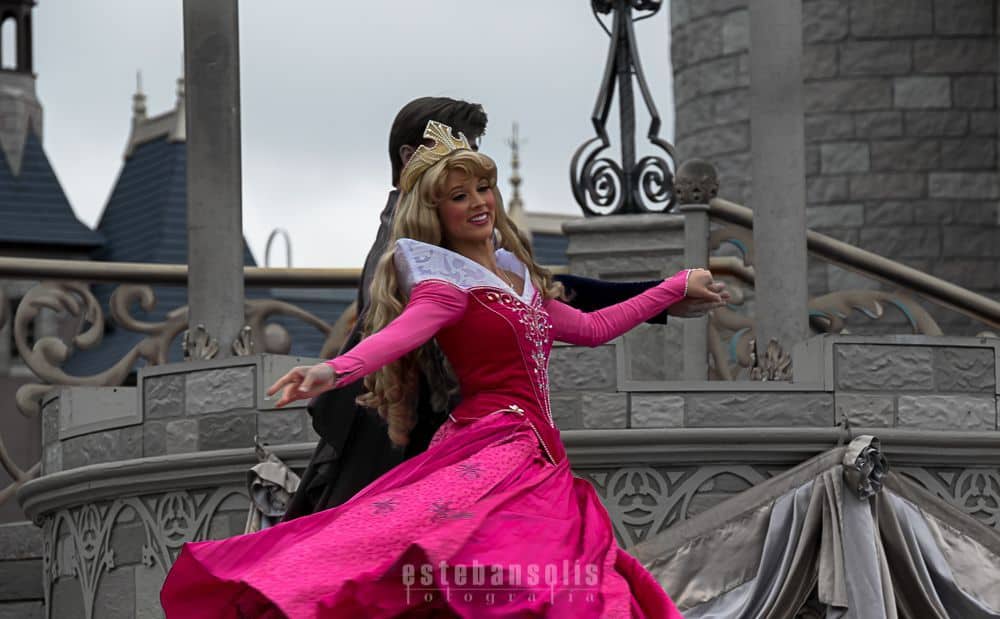 Sleeping Beauty twirls in her iconic pink gown on stage before the castle, enchanting Disneyland guests with a magical performance.