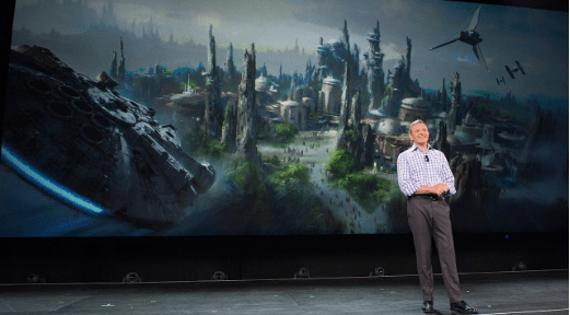 A Disney executive unveils concept art of Star Wars: Galaxy’s Edge, with iconic spaceships, thrilling fans at Walt Disney World.