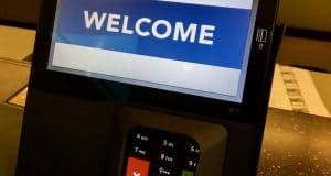 A Walt Disney World payment terminal welcomes guests, showcasing the park’s upgraded, guest-friendly payment technology.