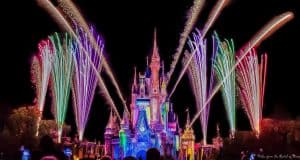 Cinderella Castle at Magic Kingdom illuminated at night, as dazzling fireworks burst in vibrant colors overhead.