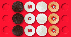 Cookies arranged in four rows spell “MOM” on bright red, some with floral designs—ideal for Disney World's Mother's Day treats.