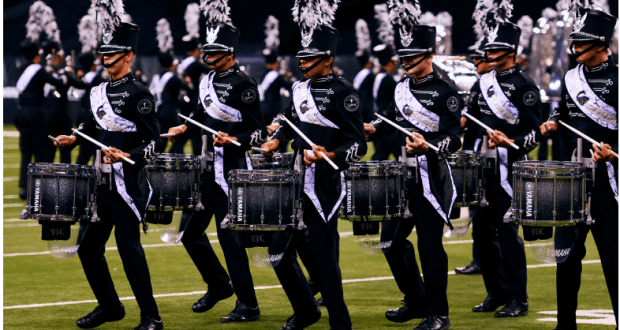 The Disney Parks drumline dazzles on the field, playing snare drums in unison as part of the Disney Performing Arts showcase.