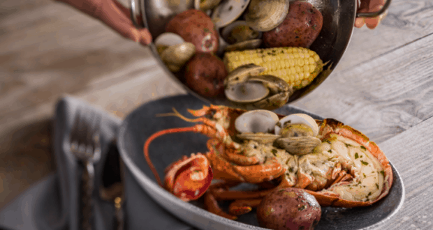 Lobster, clams, potatoes, and corn from Ale & Compass Restaurant's famous seafood boil at Walt Disney World—reservations suggested.