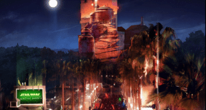 Fans wielding lightsabers fill a palm-lined avenue at Galactic Nights, with the illuminated Tower of Terror glowing behind them.