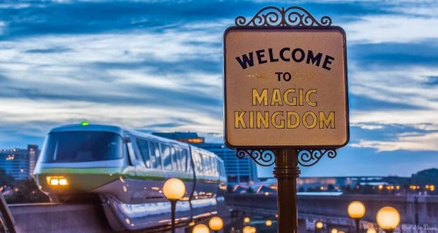 Welcome to Magic Kingdom sign illuminated at dusk with a monorail gliding by, evoking the thrill of Disney World's opening day.