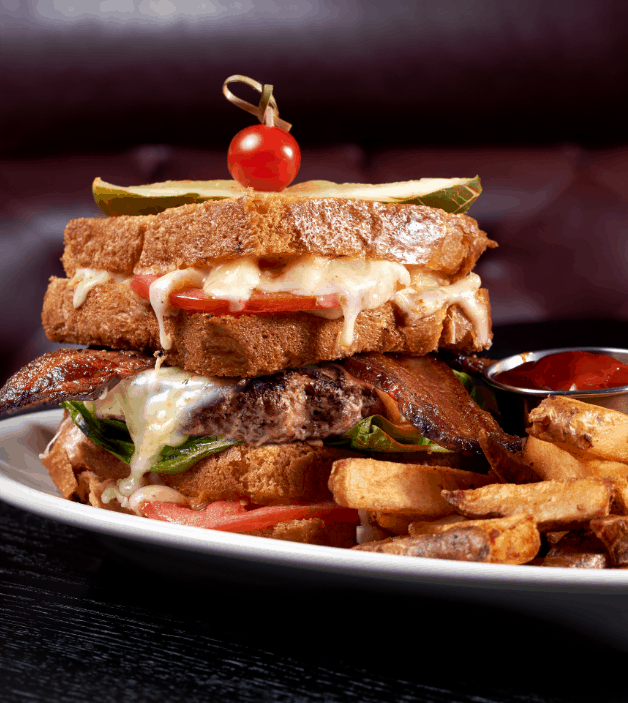 Edison’s Burger of the Month stars with sizzling cheese and bacon, served alongside fries and ketchup for a blockbuster meal.
