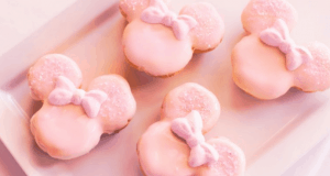 Millennial Pink mouse-shaped treats with bows line a white plate—Disney World magic for your next themed gathering.