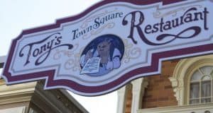 Tony’s Town Square Restaurant sign at Magic Kingdom, with a smiling dog and menu, radiating classic Disney dining charm.