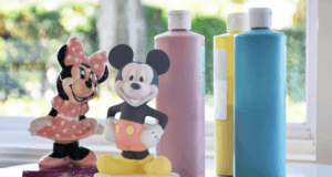 Mickey and Minnie Mouse figurines await a magical paint session with bright Disney-hued paints, recalling Disney World adventures.