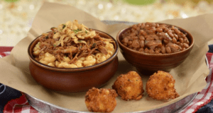Indulge in Diamond Horseshoe’s mac and cheese, loaded with pulled pork, baked beans, and crispy fried cheese balls at Disney World.