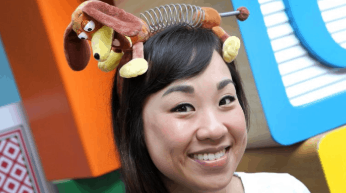 A guest at Toy Story Land shows off themed merchandise by wearing a playful Toy Story toy on her head.
