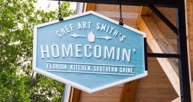 Chef Art Smith’s Homecomin’ Florida Kitchen blue sign shines at Disney Springs—inviting guests to try Southern favorites.