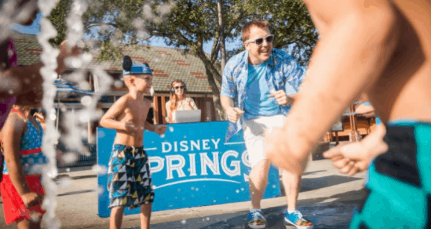 Families and kids splash in the water fountains at Disney Springs, enjoying the lively atmosphere of Walt Disney World on a sunny day.