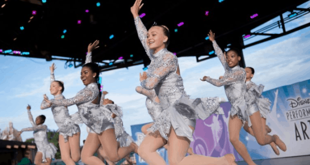 Dazzling dancers in silver costumes light up the Walt Disney World stage with an energetic National Dance Day performance.