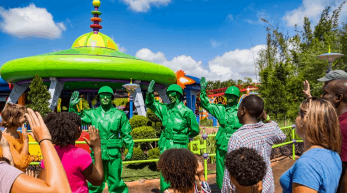 Guests wave at the Green Army Patrol from Toy Story Land in Disney’s vibrant theme park attraction.