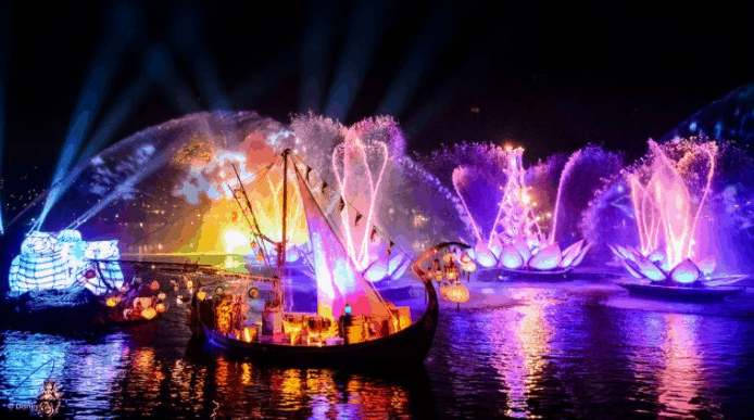 Dazzling Rivers of Light show at Disney World, with glowing boats and fountains shimmering on the lake under the night sky.