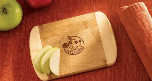 Mickey Mouse Passholder cutting board beside sliced green apple and red napkin—an epicurean must for Disney World fans.