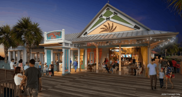 Guests relax outside a lively waterfront restaurant at Caribbean Beach, surrounded by palm trees and twinkling string lights at dusk.