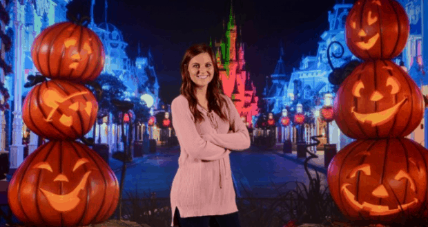 Guests enjoying PhotoPass Studio at Disney Springs, surrounded by glowing jack-o’-lantern towers and a sparkling castle backdrop.