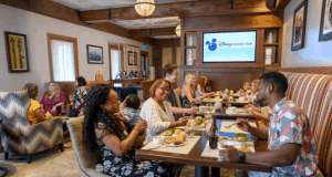 Disney fans gather at a cozy restaurant in Walt Disney World, near the Disney Vacation Club sign and Reunion Station.