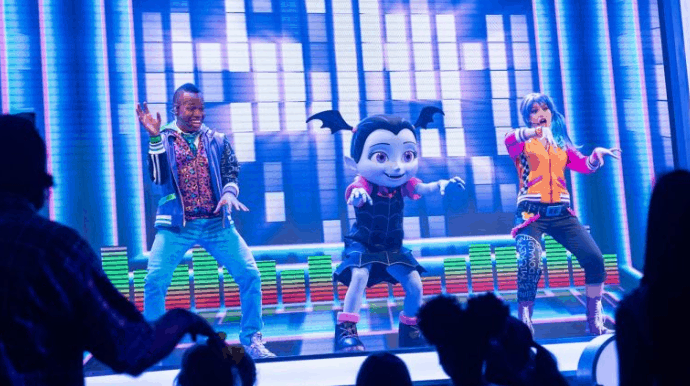 Three Disney Junior stars, including Vampirina, light up the vibrant stage with energetic dance moves at Walt Disney World.