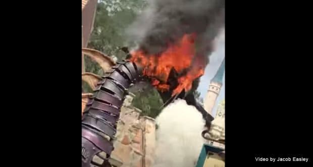 Maleficent’s parade dragon breathes real fire, smoke billowing near Cinderella Castle—a Disney World spectacle from 2018.