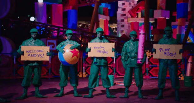 Green Army Men from Toy Story Land welcome guests at Walt Disney World with signs reading “Welcome Andys! Andy Night Play Big!” at night.