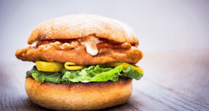 Savor our crispy chicken sandwich with lettuce, pickles, and sauce—Disney Springs’ Pepe flavors in every bite!.