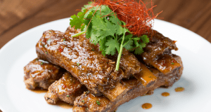Morimoto Asia’s braised pork ribs with cilantro and chili strips, plated perfectly at Walt Disney World for food-loving guests.