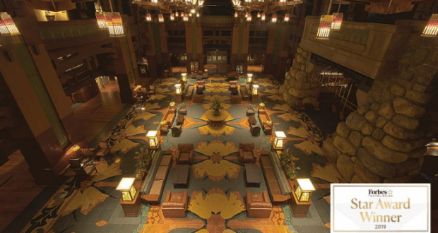 Step into Disney’s Grand Californian Hotel lobby—floral carpet, glowing lights, comfy seating, and a 2019 Forbes Star badge.