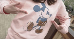 Mickey Mouse featured on a pink Briar Rose Gold Collection sweatshirt, highlighted by a fan at Walt Disney World.