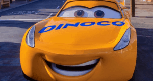 Dinoco’s yellow race car smiles on a city street, just like Lightning McQueen at Disney's Hollywood Studios in Walt Disney World.