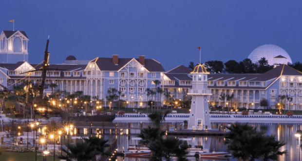 Enjoy a glowing waterfront resort and lighthouse at dusk, with a grand dome—your gateway to Pirate adventures by Disney World.