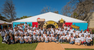 ToyFest team members in matching shirts gather by a western-themed tent, celebrating City of Hope’s cause at the festival.