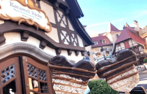 Mickey-shaped chocolate treats dipped in chocolate held up outside Karamell-Küche in EPCOT’s Germany Pavilion, Disney World.