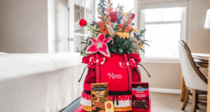 A Disney Floral & Gifts red "Mom" bag with flowers and chocolates sits in a sunlit resort room, perfect for Mother's Day magic.