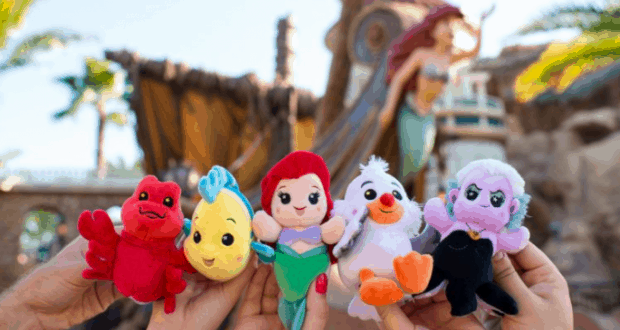 Guests show off The Little Mermaid Wishables plushes in front of an immersive themed backdrop at Walt Disney World.