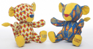 Two vibrant Lion King plush toys with "LION KING" on their paws, perfect for Disney parks guests and Lion Recovery Fund supporters.