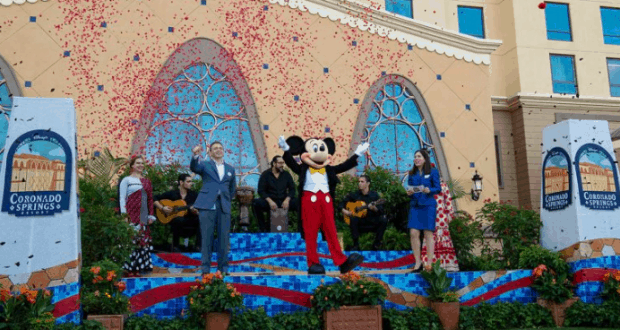 Mickey Mouse and guests celebrate onstage at Disney World's Coronado Springs as Gran Destino Tower opens, confetti raining down.