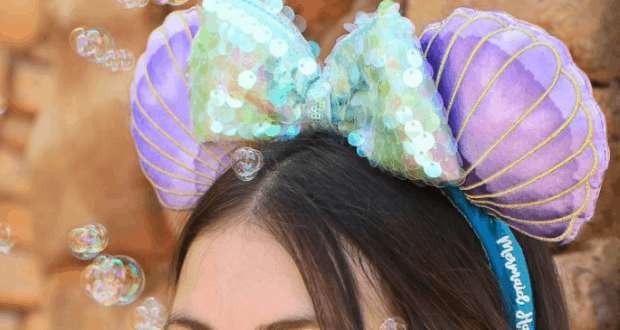 Little Mermaid 30th Anniversary headband with purple seashell ears and sequin bow, bubbles floating as fans enjoy Disney magic.