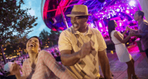 Guests dance and smile amid vibrant lights and the bustling Epcot crowd at Walt Disney World’s lively outdoor celebration.