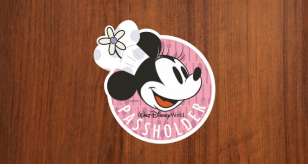 Minnie Mouse in a chef hat on a "Walt Disney World Passholder" sticker, perfect for park fans, on a wooden table.