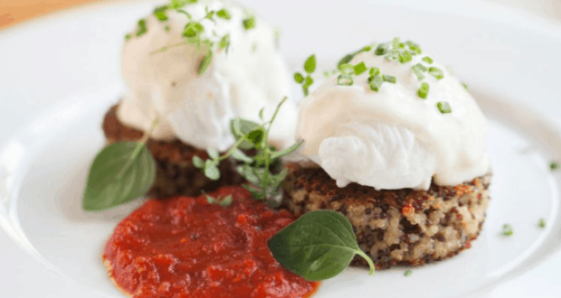 A Disney Springs treat: poached eggs on quinoa cakes with fresh herbs and tomato sauce, plated at Beatrix for brunch magic.
