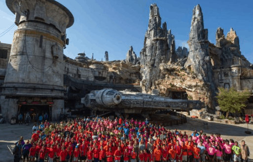 Central Florida students gather in front of the Millennium Falcon at Star Wars: Galaxy’s Edge, surrounded by rocky outcrops.