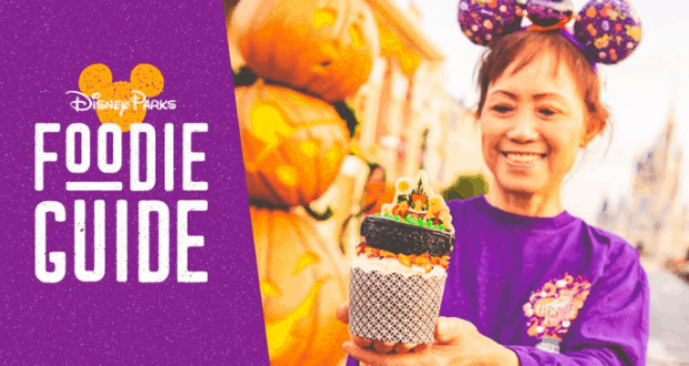 Disney fan in purple Minnie ears shows off a Halloween cupcake; Disney Parks Foodie Guide logo and pumpkins tease party treats.
