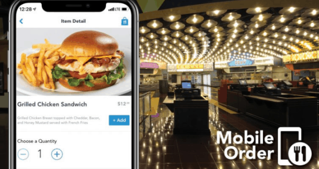 A smartphone shows a grilled chicken sandwich Mobile Order inside a brightly lit, empty Disney World quick-service restaurant.